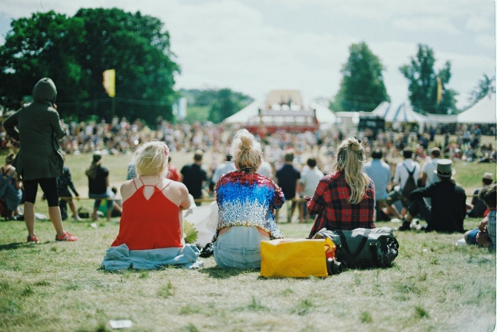 Photographie de trois jeunes femmes de dos au festival "no'mad"