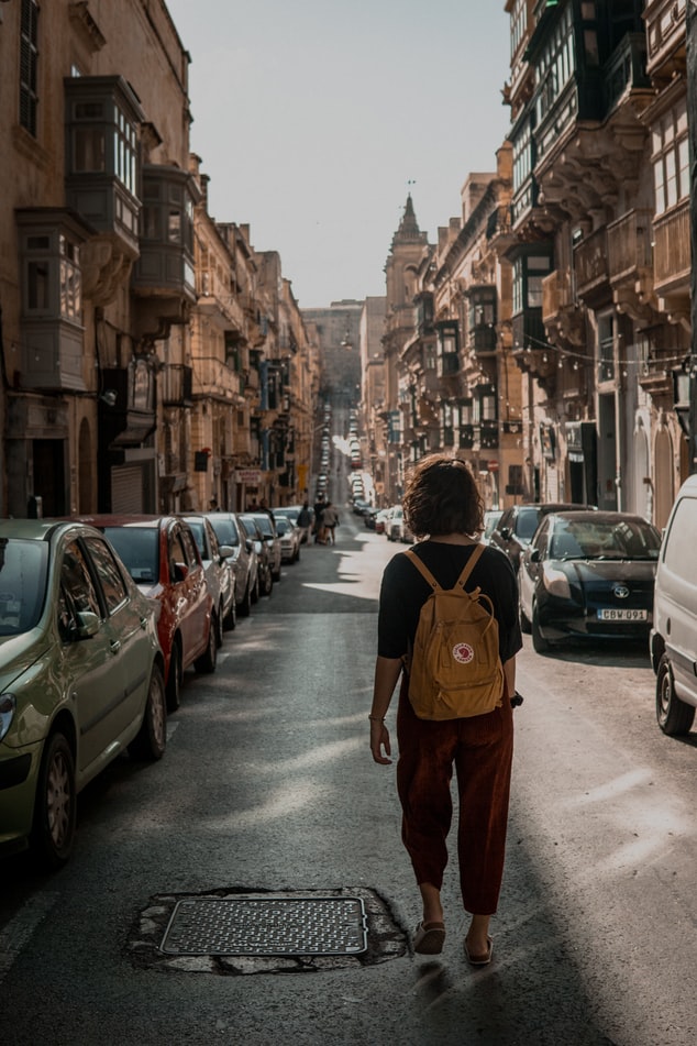 jeune femme marchant au milieu d'une rue