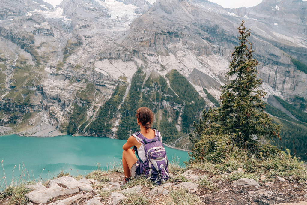 jeune femme de dos faisant face à une montagne