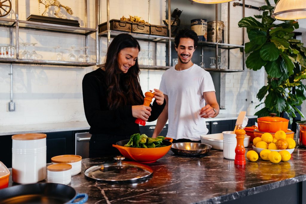 une femme et un homme cuisinant un repas