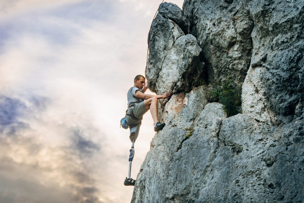 Man with prosthetic leg free mountain climbing