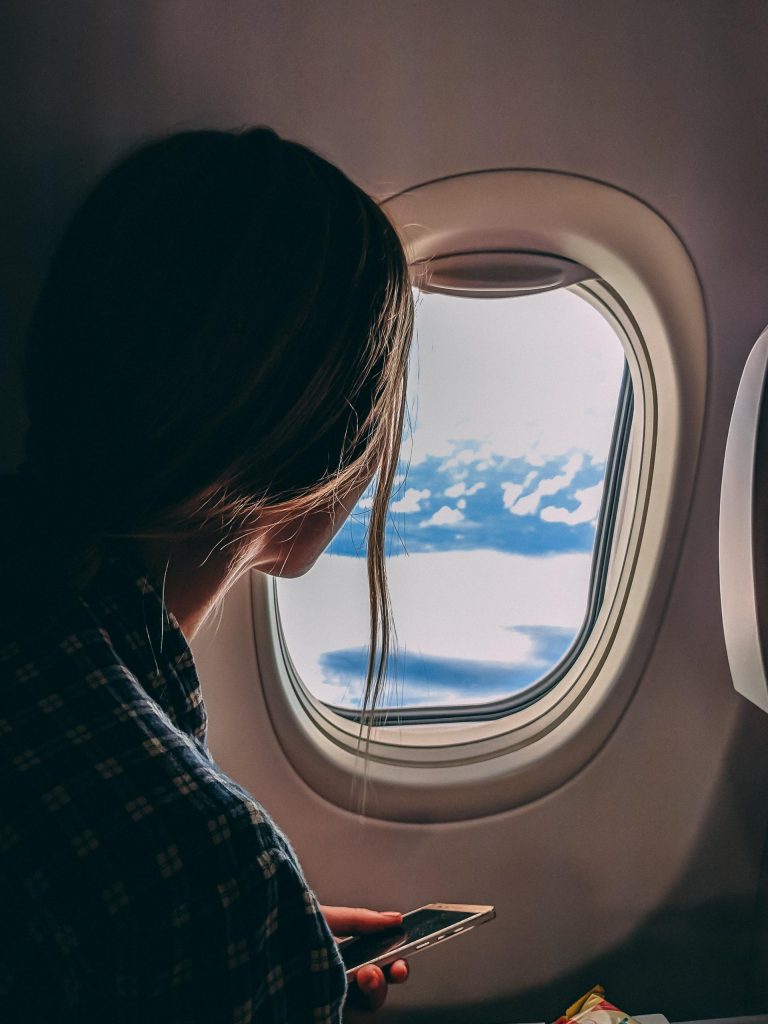 jeune femme regardant par le hublot d'un avion