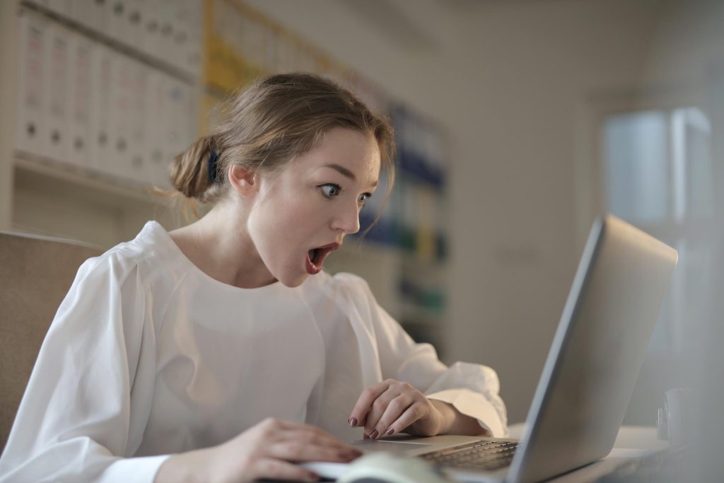 woman in white long sleeve shirt using silver laptop