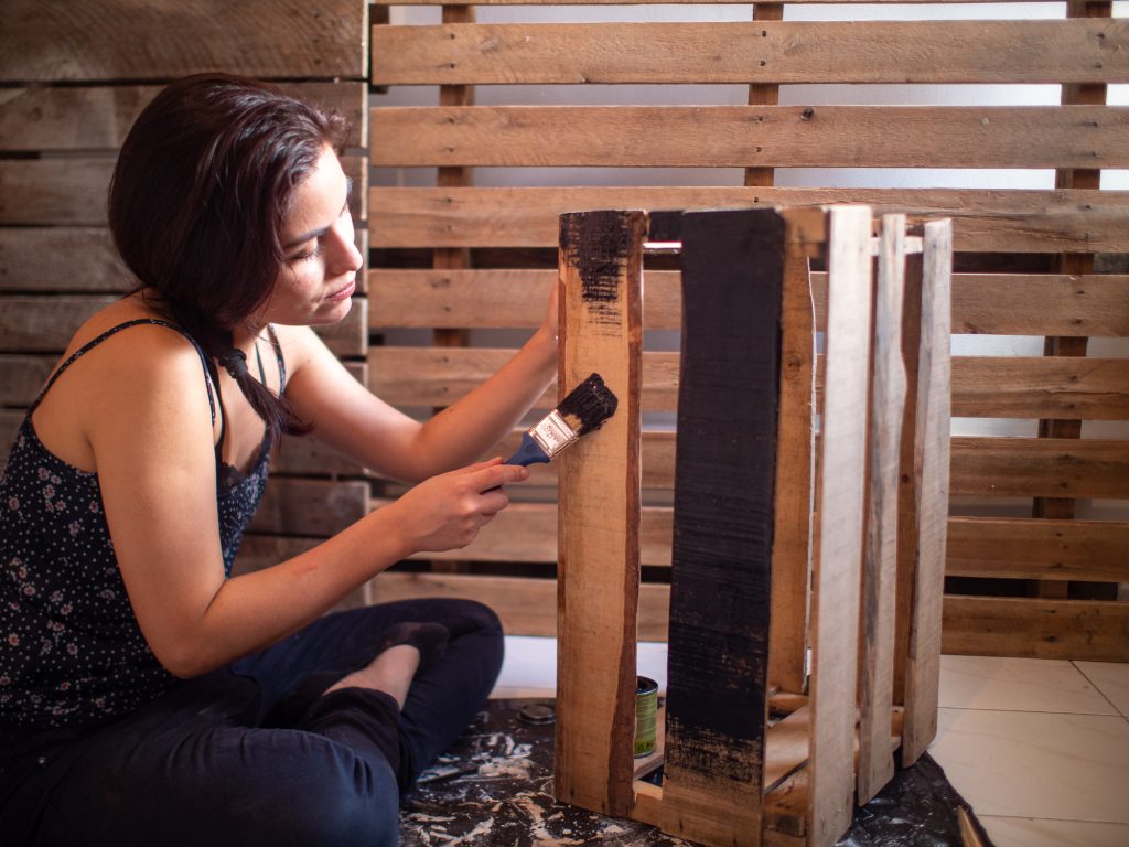 jeune femme peignant du bois