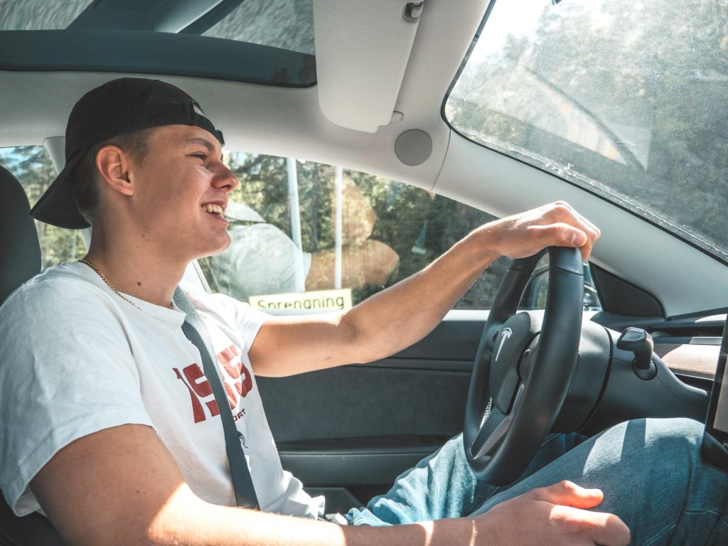 jeune homme au volant d'une voiture