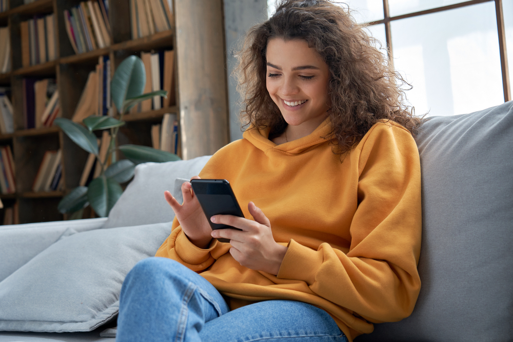 jeune femme sur un fauteuil avec son téléphone