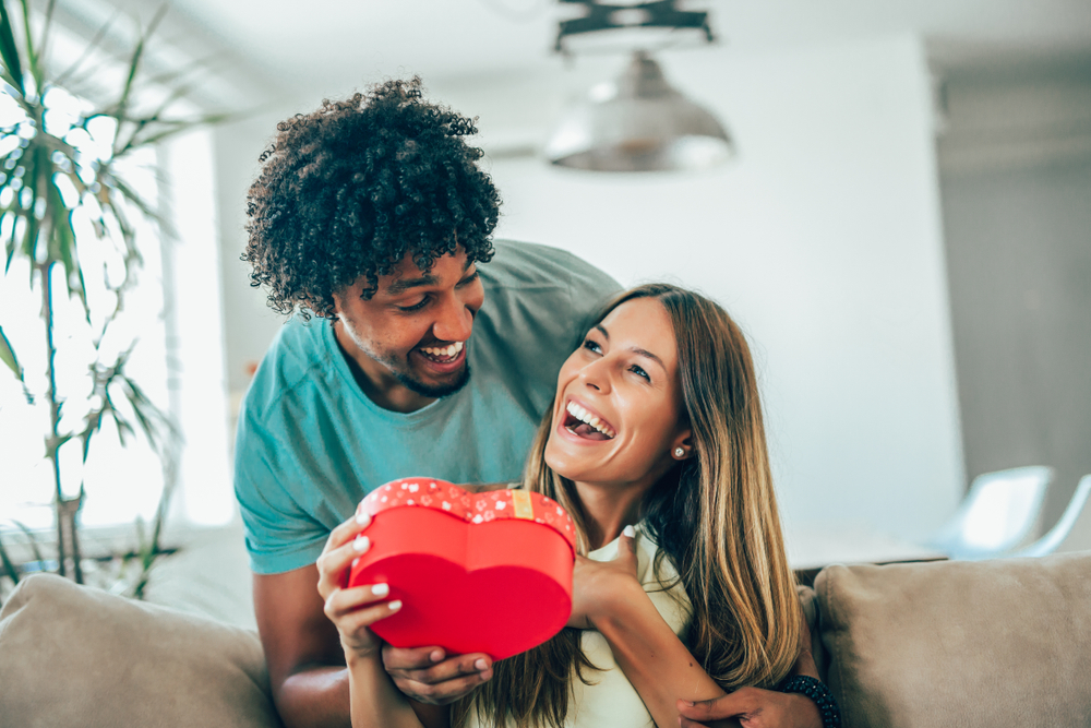 jeune homme offrant un cadeaux de saint valentin à sa copine