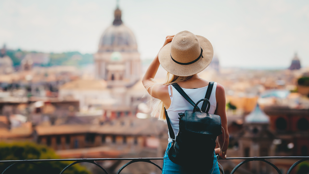 jeune femme avec un chapeau devant un monument